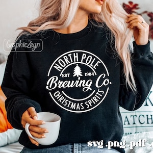 May include: A black sweatshirt with a white circle design that says "North Pole Brewing Co. Est. 1984 Christmas Spirits".
