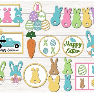 May include: A selection of colourful Easter-themed wooden cutouts. Includes bunnies, eggs, a carrot, a truck with the text "happy Easter", and decorative circles. The cutouts are in various pastel colours.