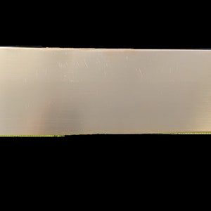 May include: A plain, rectangular, silver-colored metal sheet.
