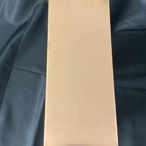 May include: A rectangular sheet of brushed gold metal.