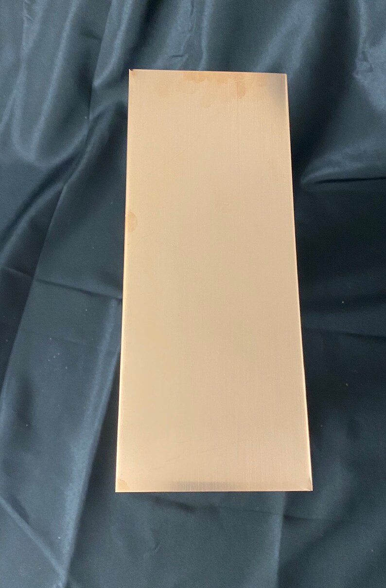 May include: A rectangular sheet of brushed gold metal.