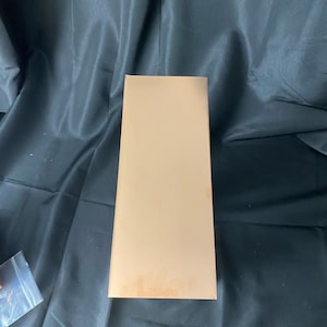 May include: A plain, light brown cardboard box with a rectangular shape.