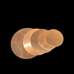 May include: A set of six copper-colored metal discs of varying sizes, arranged in a graduated pattern. The discs are smooth and have a slightly shiny finish.