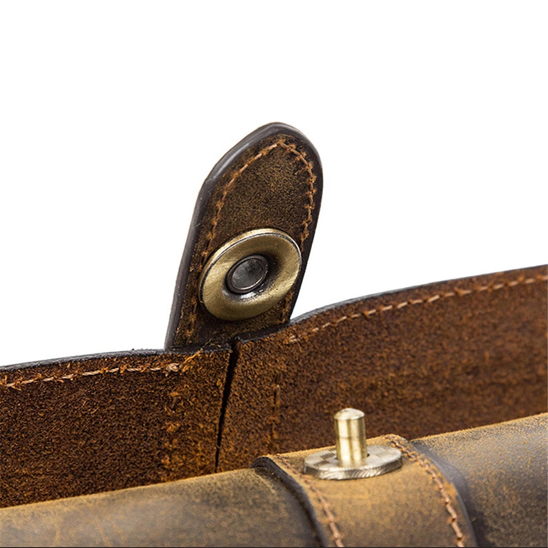 Peut inclure: Gros plan sur un sac en cuir marron avec une fermeture &agrave; pression en m&eacute;tal. Le sac a un aspect vieilli et est fait de cuir de haute qualit&eacute;.