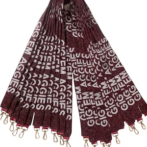 Peut inclure: Un ensemble de 20 sangles en perles marron avec du texte blanc qui dit "Gig 'Em Aggies". Les sangles ont des fermoirs dorés.