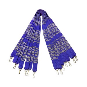 May include: A set of ten purple lanyards with gold lettering that reads "GEAUX TIGERS". The lanyards have gold metal clasps.