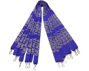 May include: A set of ten purple lanyards with gold lettering that reads "GEAUX TIGERS". The lanyards have gold metal clasps.