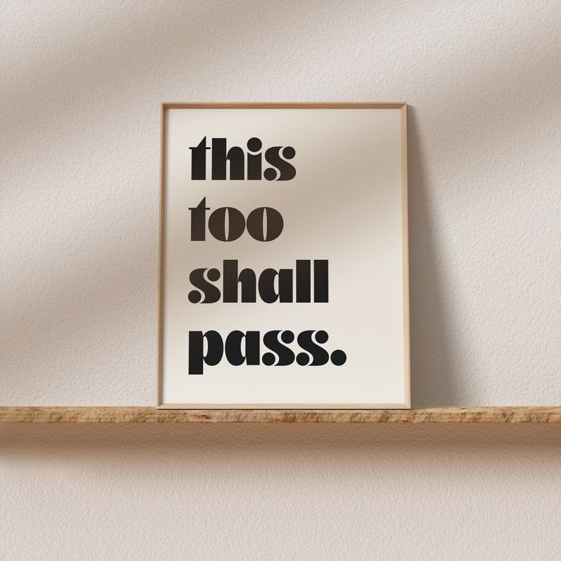 K&ouml;nnte beinhalten: Ein gerahmter Druck mit dem Text "this too shall pass." in fetten schwarzen Buchstaben auf wei&szlig;em Hintergrund.