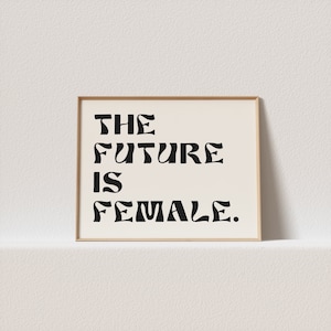 May include: A framed print with the text "THE FUTURE IS FEMALE." in black stylized lettering on a white background.