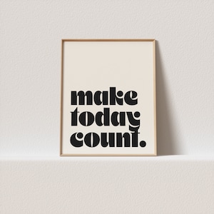 Puede incluir: Una impresión enmarcada con el texto "make today count." en letras negras en negrita sobre un fondo crema.