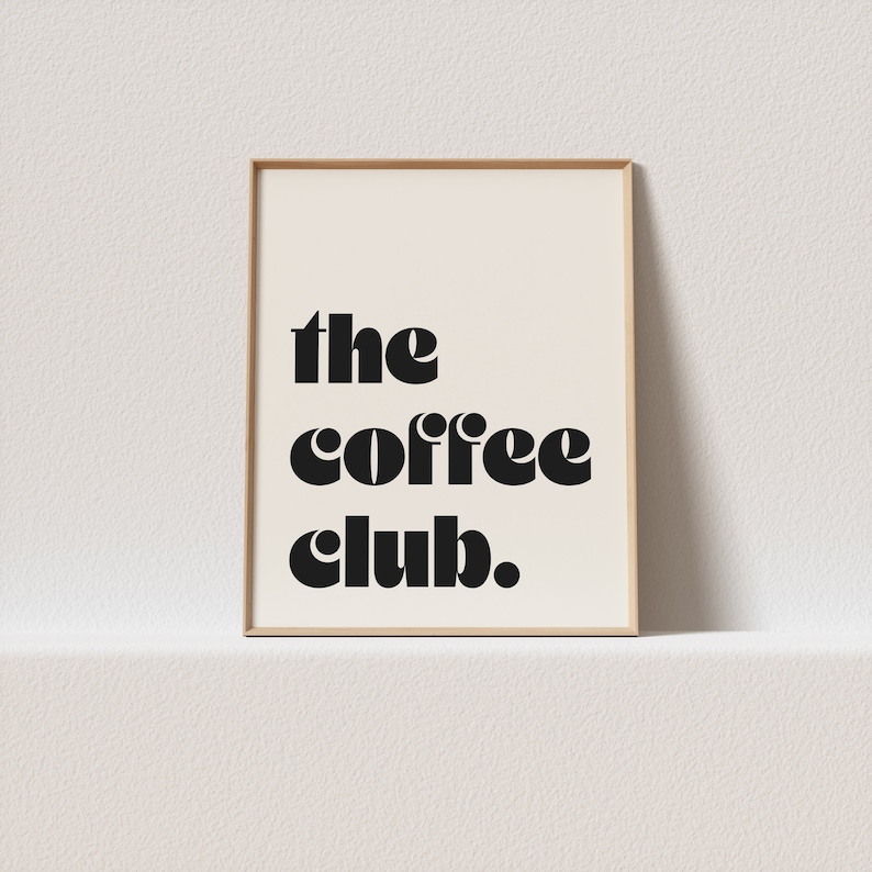 May include: A framed print with the text "the coffee club" in a bold, black font on a white background.