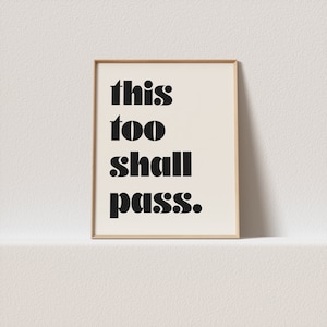 May include: A framed print with the text "this too shall pass." in black bold letters on a white background.