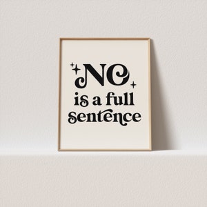 May include: A framed print with the words "NO is a full sentence" in black, stylized lettering. The text is centered on a cream-colored background, with a simple wooden frame. The design includes star-like embellishments.