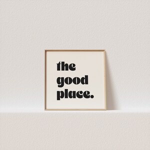 May include: A framed print with the text "the good place." in black bold letters on a white background.