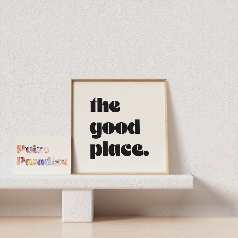 May include: A framed print with the text "the good place." The print is on a white shelf with a smaller print on the left that says "Poise Paradise".