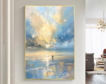 以下が含まれることがあります： 金色の空とビーチを歩く2人の人物を描いた海の風景画。絵は金色の額縁に入っています。