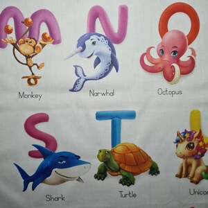 May include: A white fabric featuring colorful illustrations of animals and the alphabet. The letters M, N, O, S, T, and U are displayed with corresponding images of a monkey, narwhal, octopus, shark, turtle, and unicorn. Each image has a name below it.