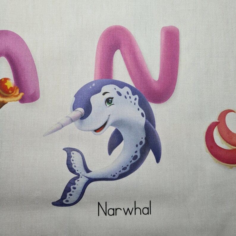 May include: A cartoon illustration of a narwhal with a long, spiraled tusk, in shades of blue and white. The word "Narwhal" is printed in black below the image. A large pink letter "N" is behind the narwhal.