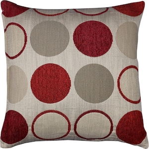 May include: A cream coloured throw pillow with a red and beige polka dot pattern. The pillow is made of a soft, textured fabric.