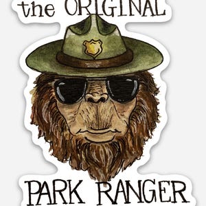 May include: A sticker featuring a watercolor illustration of a Bigfoot wearing sunglasses and a park ranger hat. The text at the top reads "the ORIGINAL" and the text at the bottom reads "PARK RANGER". The Bigfoot has brown fur and a serious expression.