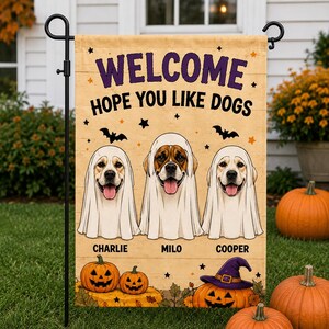 May include: A rectangular garden flag with a light tan background featuring the text WELCOME HOPE YOU LIKE DOGS in purple and black. Three dogs are illustrated wearing white ghost costumes, labeled CHARLIE, MILO, and COOPER, with bats, stars, and jack-o'-lanterns.