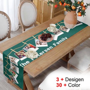 Puede incluir: Un camino de mesa verde con el texto "The Petersen Family" y fotos colgadas de un diseño de cuerda dorada. El camino de mesa está sobre una mesa de madera con un jarrón de flores y dos tazas de té.