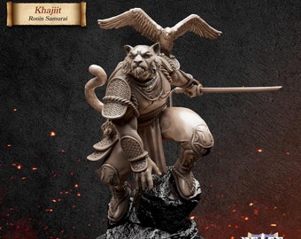 Puede incluir: Una figura miniatura de Khajiit Ronin Samurai, pintada en color marrón claro, sosteniendo una katana y de pie sobre una roca. La figura tiene una cabeza de gato y una cola larga. Un pájaro está posado en el hombro de la figura.