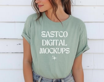 May include: A sage green t-shirt with the text "EASTCO DIGITAL MOCKUPS" in white. The shirt has a relaxed fit and rolled up sleeves.