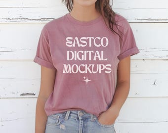 May include: A mauve t-shirt with the text "EASTCO DIGITAL MOCKUPS" in white. The shirt is being worn by a person with long brown hair.