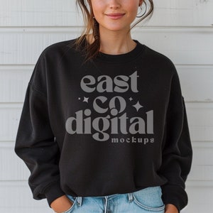 May include: A black cropped sweatshirt with the text "east co digital" in a retro font. The text is in gray and the sweatshirt has a relaxed fit.