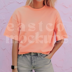 May include: A peach-colored short-sleeved t-shirt with a crew neck. The shirt is made of a soft, comfortable fabric and has a relaxed fit.