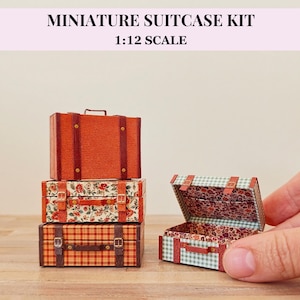 以下が含まれることがあります： 1:12スケールのミニチュアスーツケースキット。積み重ねられた3つのスーツケースと1つの開いたスーツケースが含まれています。スーツケースには、無地のオレンジ、花柄、チェック柄などのさまざまなパターンがあり、茶色のストラップと金属製のバックルが付いています。