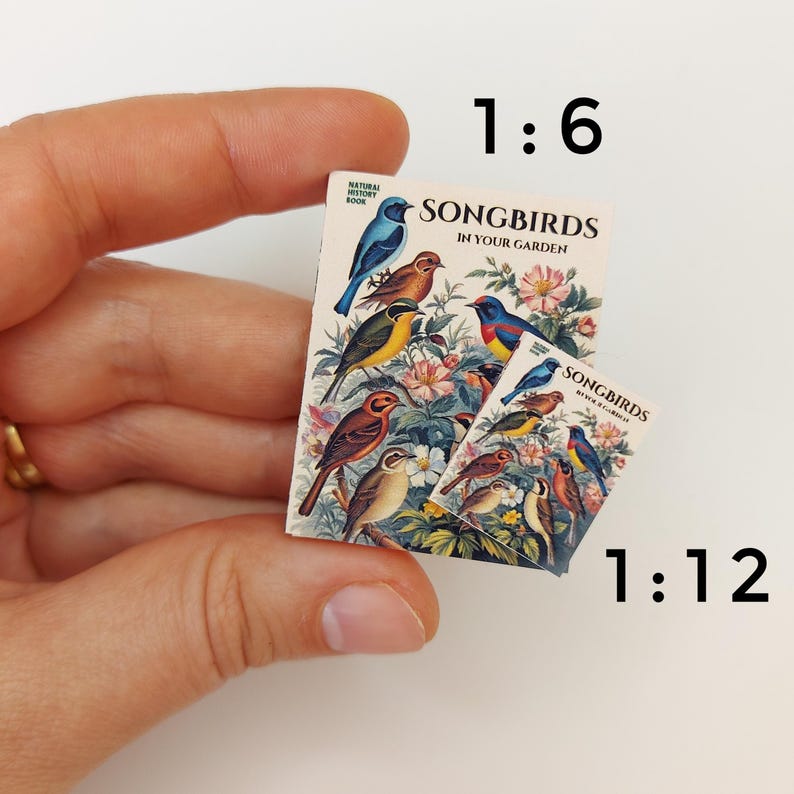 Puede incluir: Dos libros en miniatura titulados "Songbirds in Your Garden" con coloridas ilustraciones de p&aacute;jaros. El libro m&aacute;s grande est&aacute; a escala 1:6 y el m&aacute;s peque&ntilde;o est&aacute; a escala 1:12.