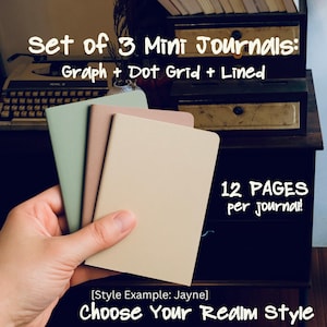 May include: A set of three mini journals in pastel colors: mint green, tan, and beige. The journals are labeled "Graph + Dot Grid + Lined" and have 12 pages each. Text reads "Choose Your Realm Style."