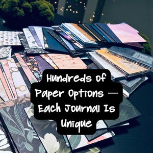 May include: A collection of rectangular journals with various patterned covers, including floral, botanical, and celestial designs. The text "Hundreds of Paper Options &mdash; Each Journal Is Unique" is centered in black. The URL "naomirosesco.etsy.com" is at the bottom.
