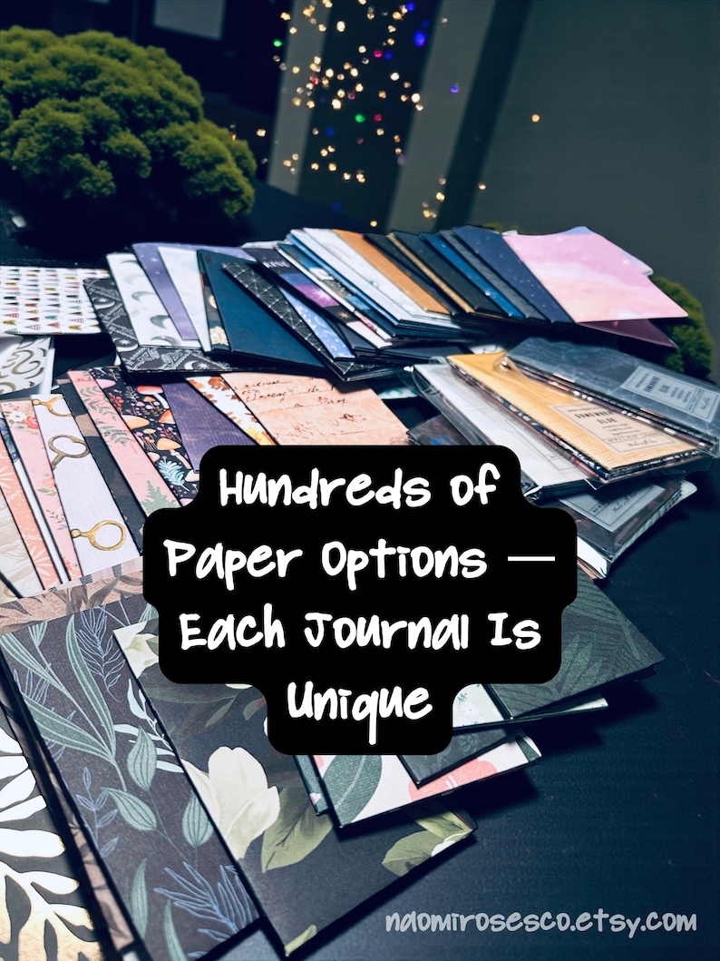 May include: A collection of rectangular journals with various patterned covers, including floral, botanical, and celestial designs. The text "Hundreds of Paper Options &mdash; Each Journal Is Unique" is centered in black. The URL "naomirosesco.etsy.com" is at the bottom.
