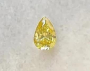 May include: A pear-shaped, fancy vivid yellow diamond. The gemstone has a brilliant cut, showcasing its internal facets. The diamond's color is a vibrant, intense yellow, and it appears to be set against a neutral background.
