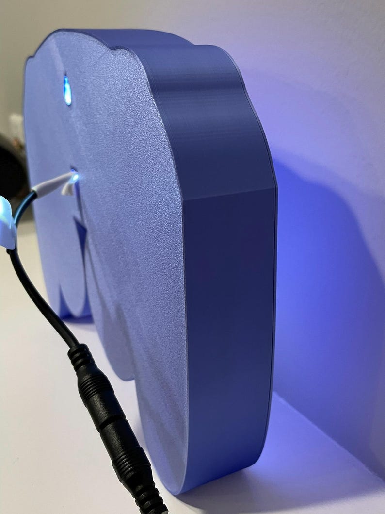 May include: A blue, 3D printed cloud-shaped night light with a white cord and a black power adapter. The light is illuminated with a blue glow.