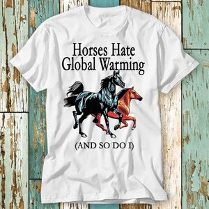 Może przedstawiać: Biała koszulka z ilustracją czarnych i czerwonych koni i tekstem "Horses Hate Global Warming (AND SO DO I)"