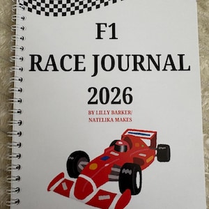 May include: A spiral-bound notebook with the text "F1 RACE JOURNAL 2026" and a red race car illustration. The top of the notebook features a black and white checkered flag design. The notebook is by Lilly Barker/ Natelika Makes.