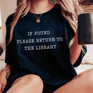 May include: A black t-shirt with the text "IF FOUND PLEASE RETURN TO: THE LIBRARY" printed in white.