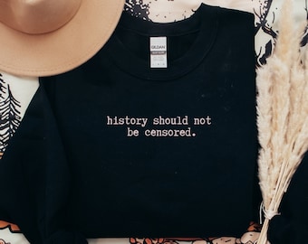 May include: Black sweatshirt with the text "history should not be censored." printed in white.