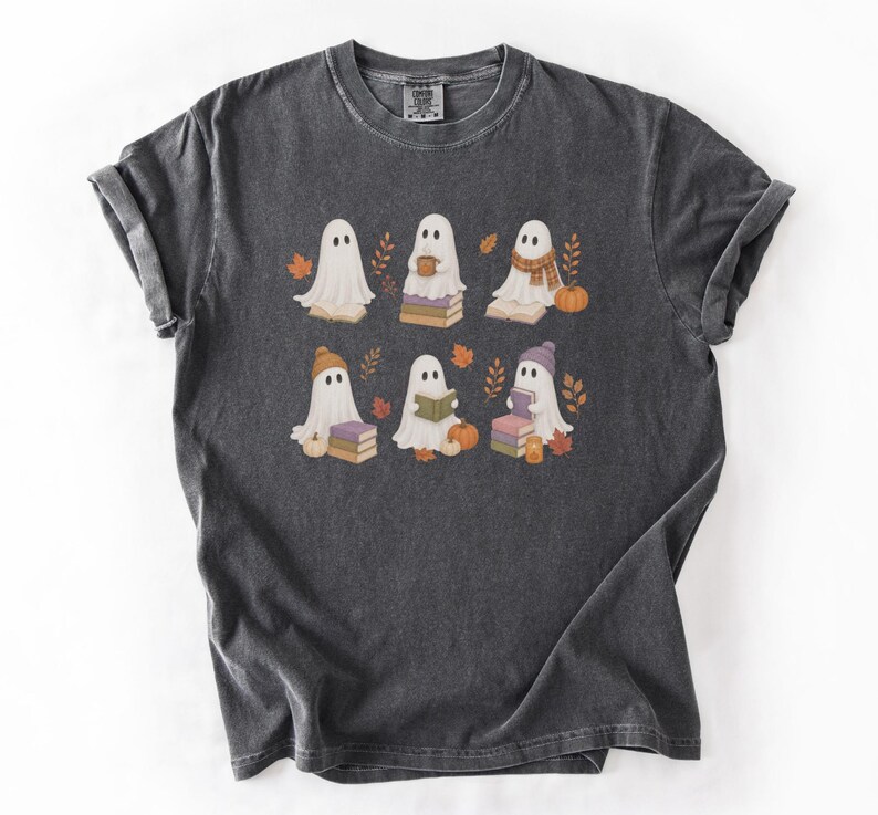 Pepper Comfort Colors shirt featuring six bookish ghosts reading books with pumpkins, fall leaves, cozy hats, scarves, and warm drinks.