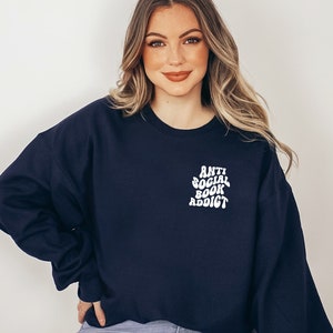 May include: Navy blue sweatshirt with the text "Anti Social Book Addict" in white, a perfect gift for book lovers. The sweatshirt is a comfortable, casual style.
