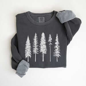 May include: A dark gray sweatshirt with a white print of five stylized pine trees.