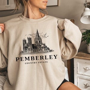 May include: A beige sweatshirt with a black graphic of a building and the text "Pemberley Country Estate".