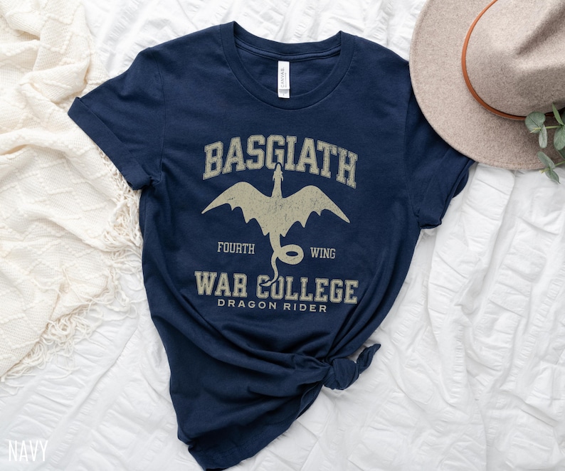 May include: Navy blue t-shirt with a white graphic of a dragon and the text "Basgiath Fourth Wing War College Dragon Rider".
