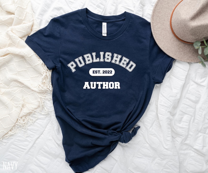 May include: Navy blue t-shirt with white text that reads "PUBLISHED EST. 2022 AUTHOR".