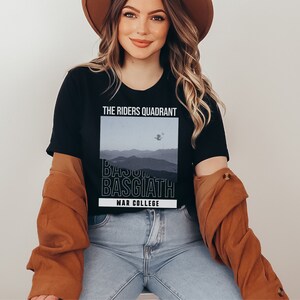 K&ouml;nnte beinhalten: Ein schwarzes T-Shirt mit einem Grafikdruck einer Bergkette und dem Text "The Riders Quadrant, Basgiath, War College".