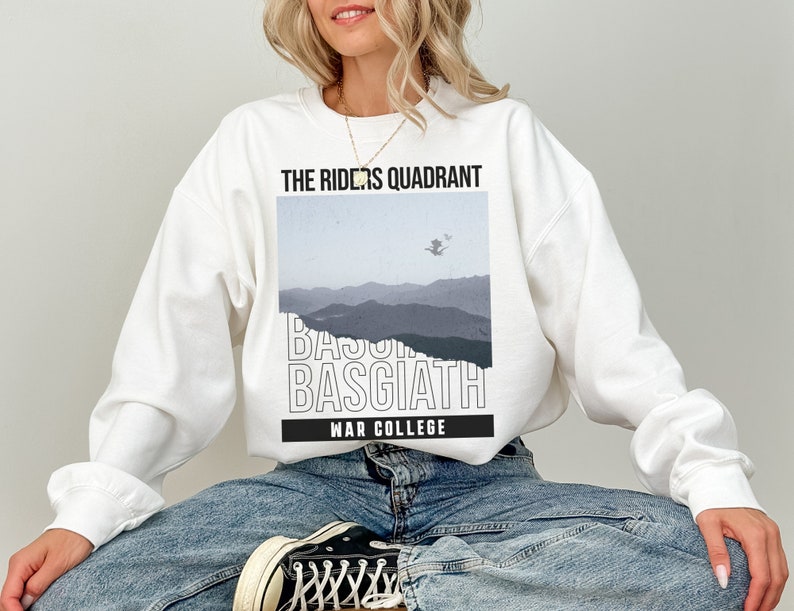 Puede incluir: Sudadera blanca con un estampado gr&aacute;fico de una cordillera y el texto "The Riders Quadrant Basgiath War College".